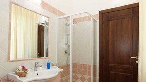 A bathroom with a sink, mirror, and shower enclosure. - B&B treatment in La Maddalena, Sardinia (La Maddalena)
