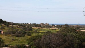 A rural landscape with scattered houses, a clear sky, and a view of the sea. - B&B treatment in La Maddalena, Sardinia (La Maddalena)