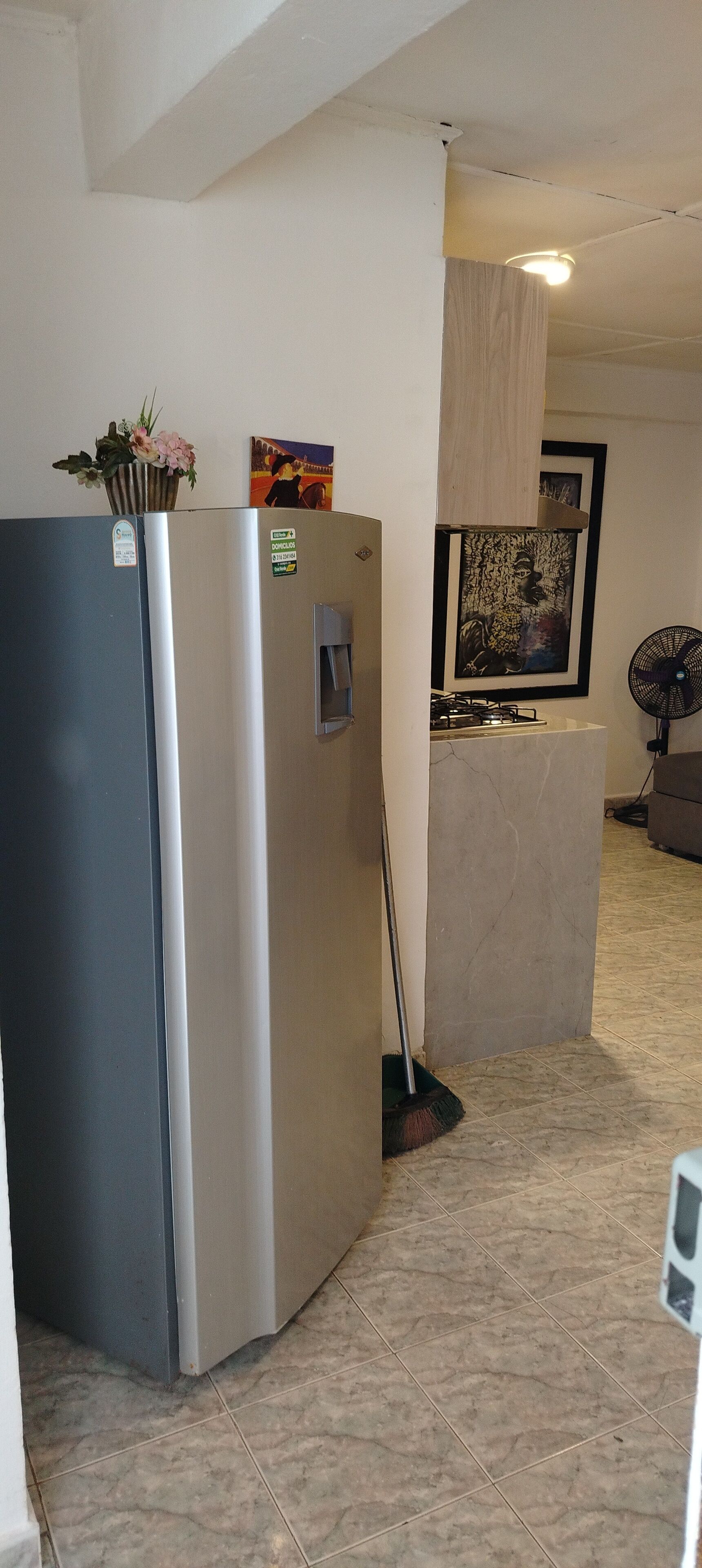 Eine Küche mit Kühlschrank, Herd und Ventilator.