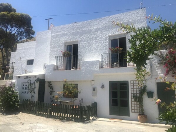 A white building with balconies, a wooden fence, and potted plants. - Holiday Flat With Sea Views (Mojácar)