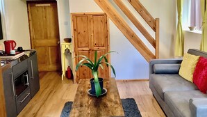 Una sala de estar con techo de madera, un sofá, una mesa de centro y una planta en maceta.