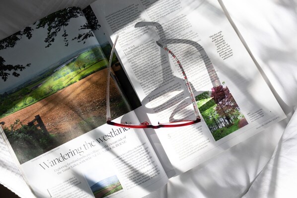 An open book with a landscape image on the left page and a silhouette of a person on the right page. - Kingfisher Lodge, Redlake Farm (Somerton)