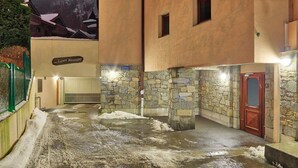 En hotellentrél med stenmurar och ett snötäckt område framför.