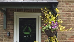 Uma porta branca com um painel de vidro exibindo o texto "ASH HOLIDAY COTTAGE".