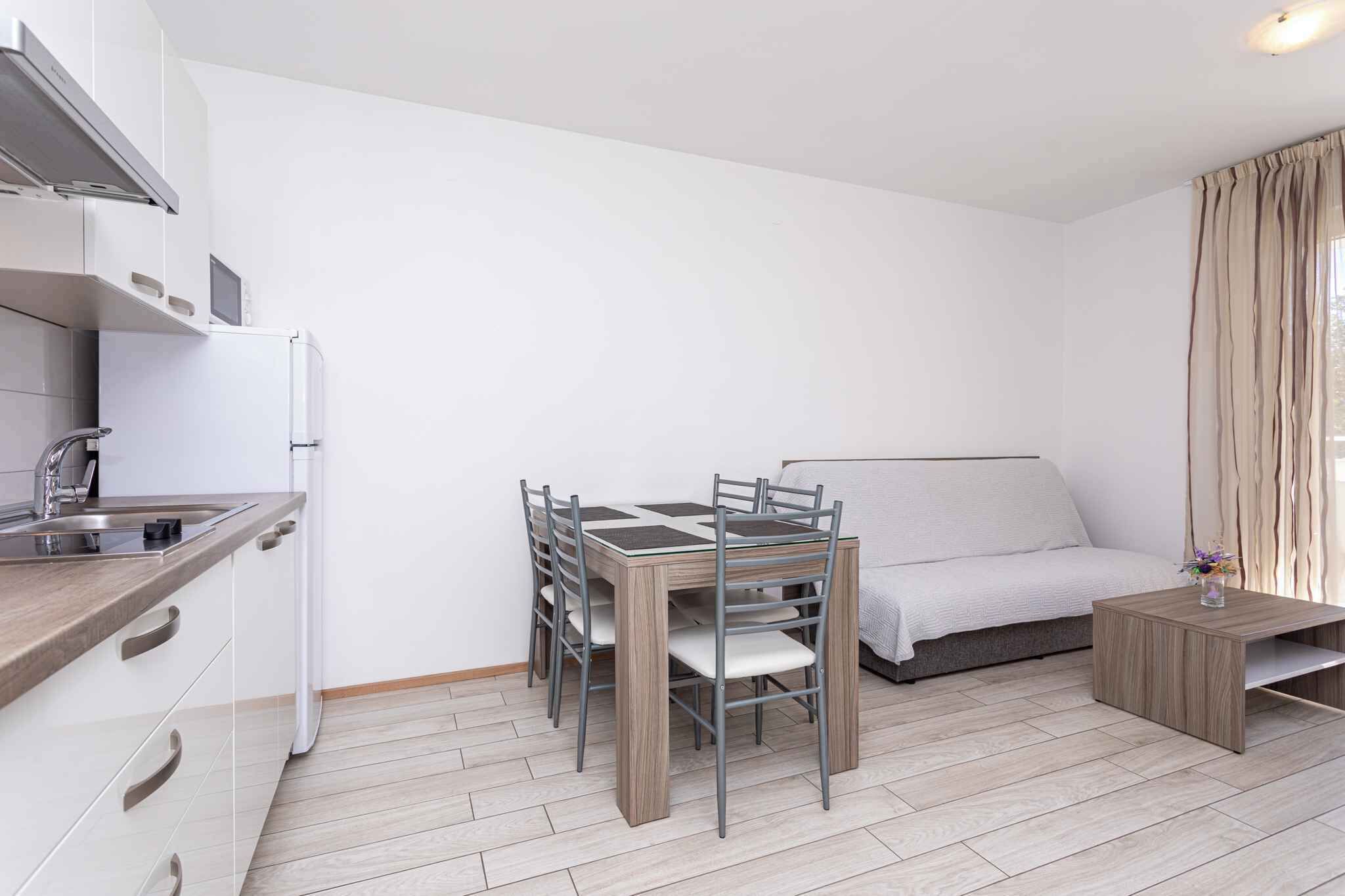 Una cocina compacta con una mesa de comedor y sillas, un sofá y una pequeña mesita.