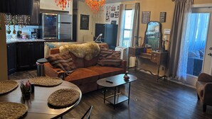 A cozy living room with a sofa, coffee table, and a dining area with a table and chairs.