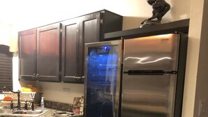 A modern kitchen with dark cabinets, stainless steel appliances, and a built-in oven.