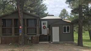 A two-story cabin with a front door, a small porch, and a garage.