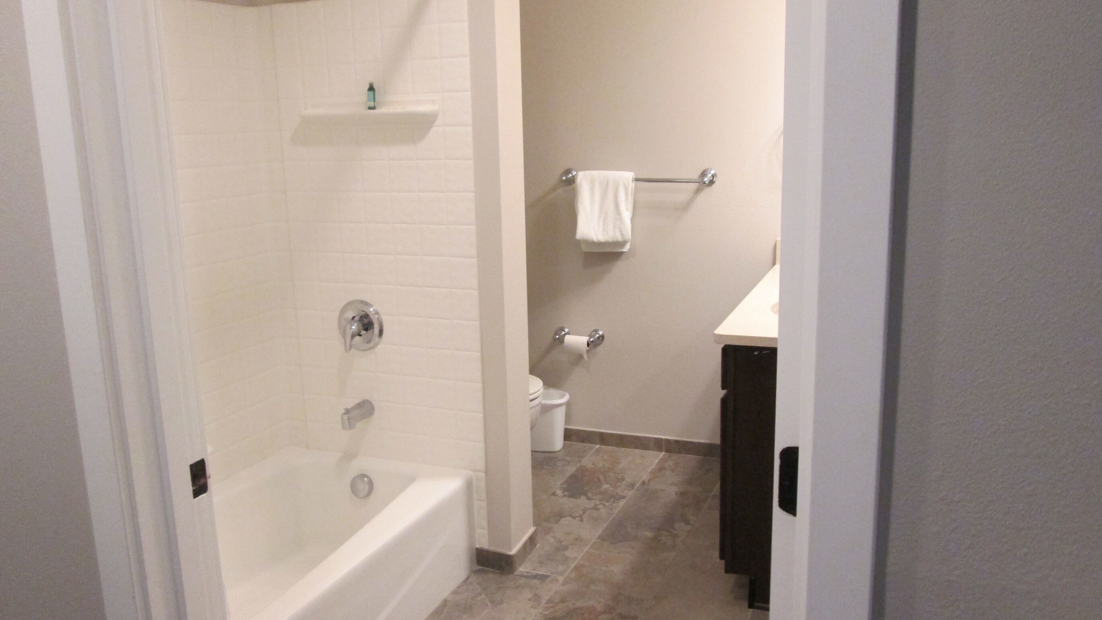 A bathroom with a bathtub, toilet, and sink.