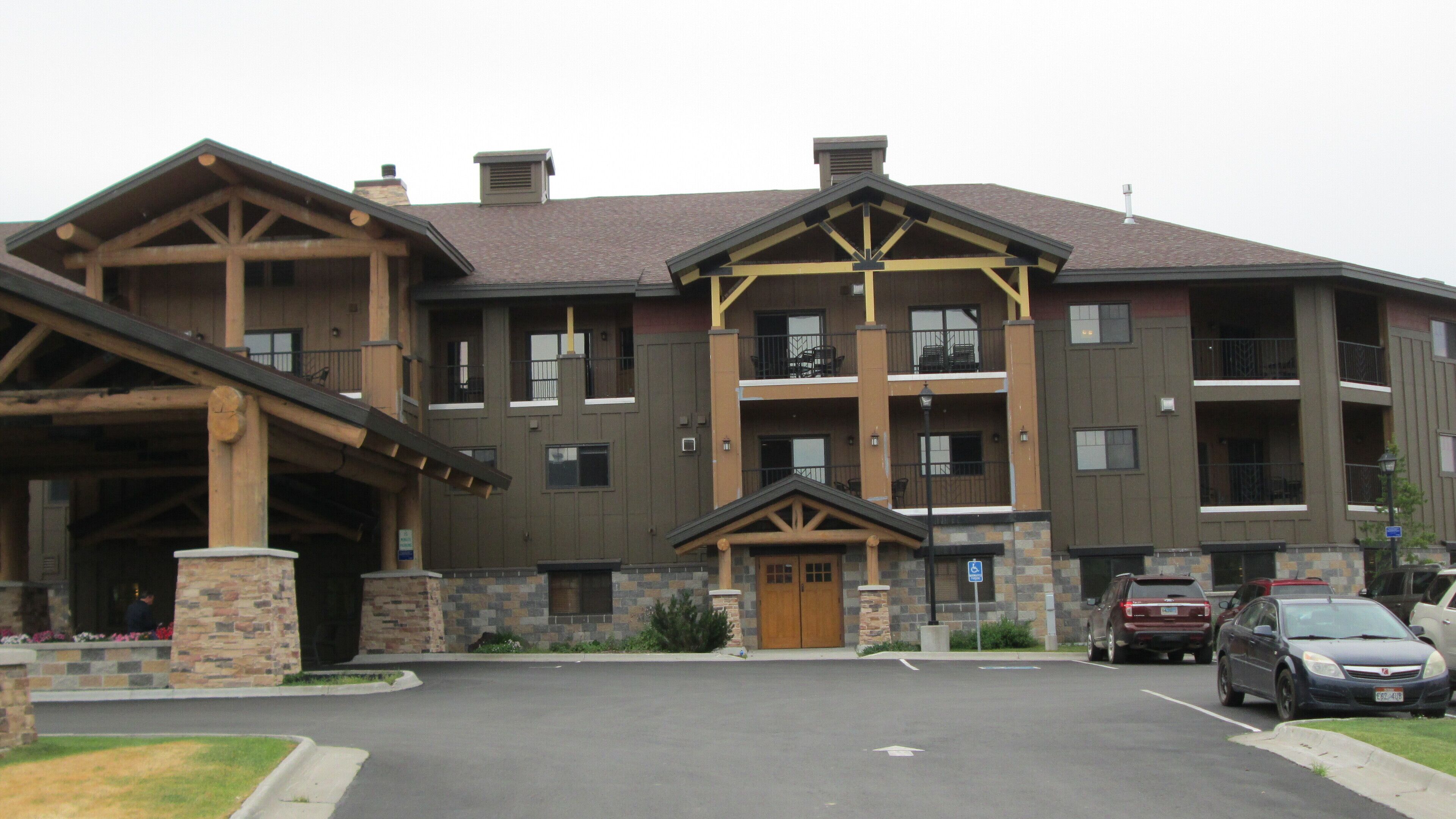 Un hôtel à plusieurs étages, doté d’une façade en pierre, de poutres en bois et d’une entrée abritée.