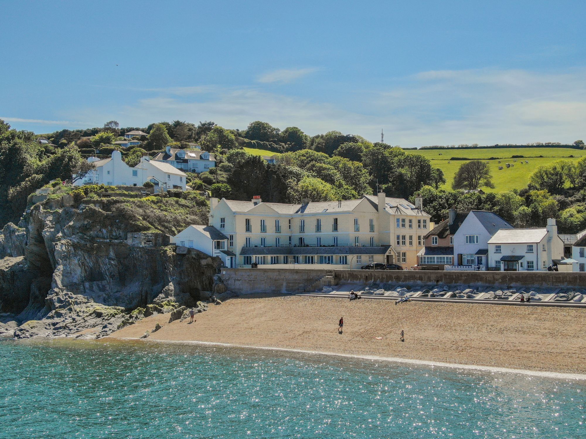 Un bâtiment à plusieurs étages situé sur la côte, sur une falaise surplombant une plage.