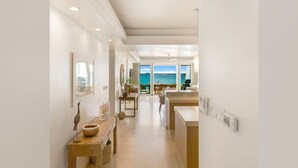 Un pasillo moderno de hotel con vista al mar, un comedor y un mostrador de recepción.