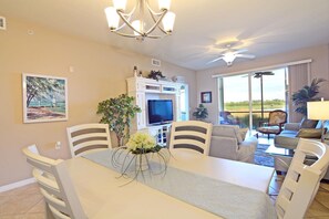 Relax in the living room with a flat-screen TV, dining table, and comfortable seating area.