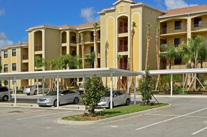 Experience the charm of this multi-story hotel, featuring balconies on every floor and lush palm trees in the front.