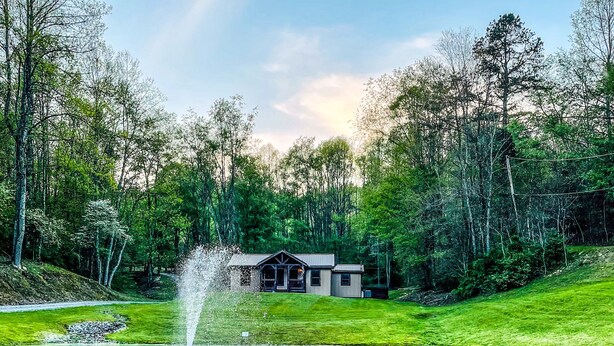 A house with a pond and a fountain in a forested area. - Charming cottage with pond in Heart of New River Gorge (Victor)