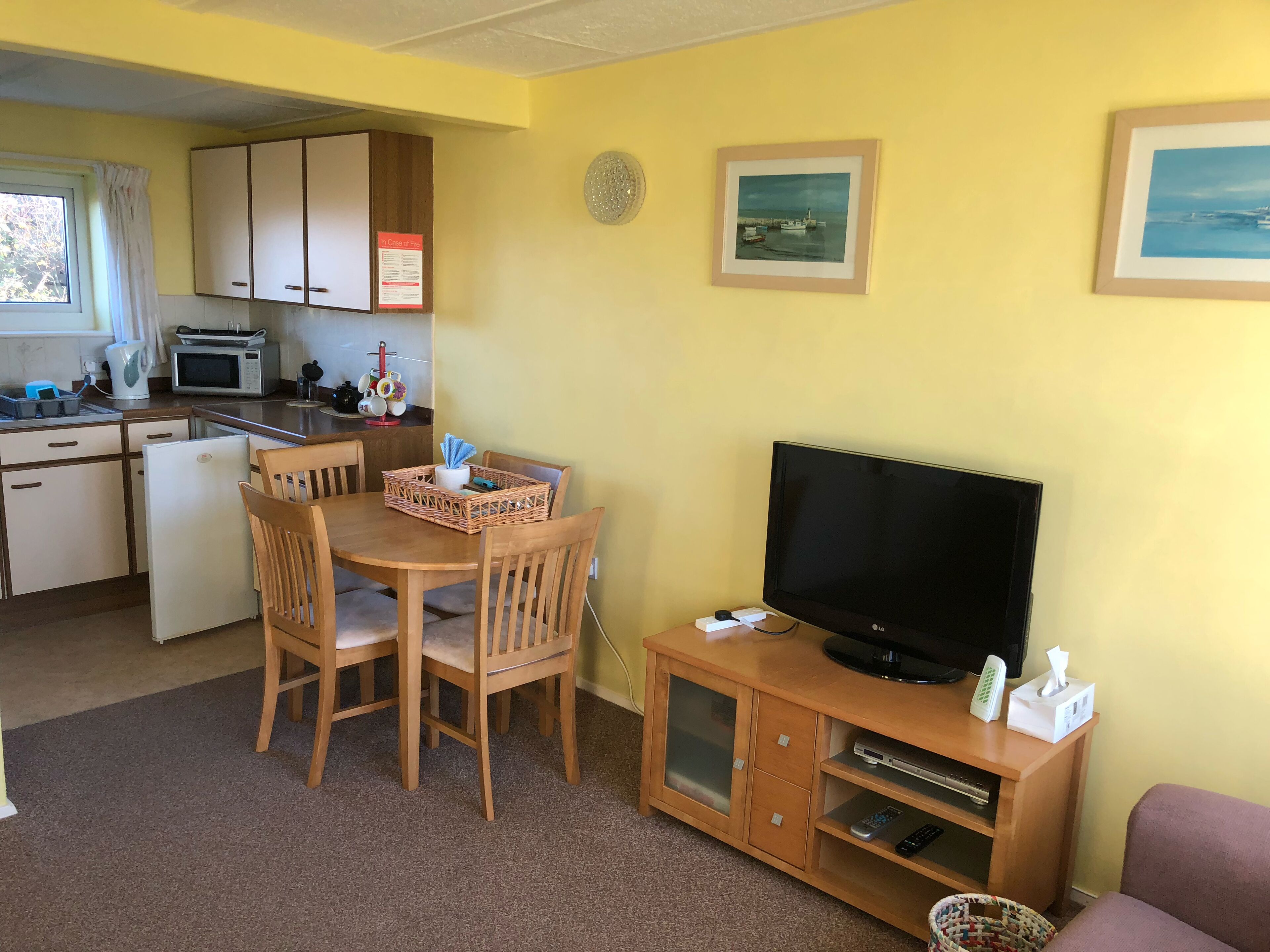 A compact living space with a kitchenette, a dining area, and a television.
