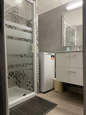 Chuveiro, secador de cabelo, toalhas de banho, sabonete