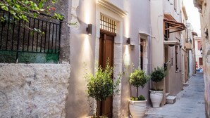 A narrow street with buildings, potted plants, and a staircase. - Alice Residence - Two Storey Luxury Residence in the Heart of Rethymno Old Town (Rethymno)