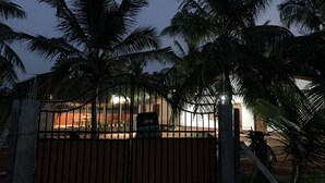 A gated area with palm trees and a building in the background.