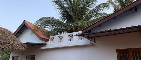A traditional building with a thatched roof, white walls, and wooden windows.