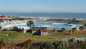 Een resort met een groot zwembad, toegang tot het strand en uitzicht op de oceaan.