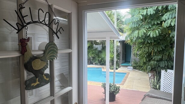 Una puerta con un cartel de 'WELCOME' y un gallo decorativo.