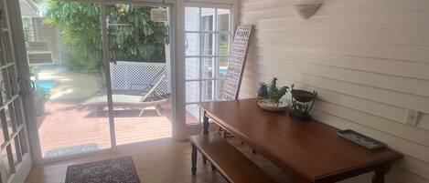 A room with a wooden table, bench, and a ceiling fan.