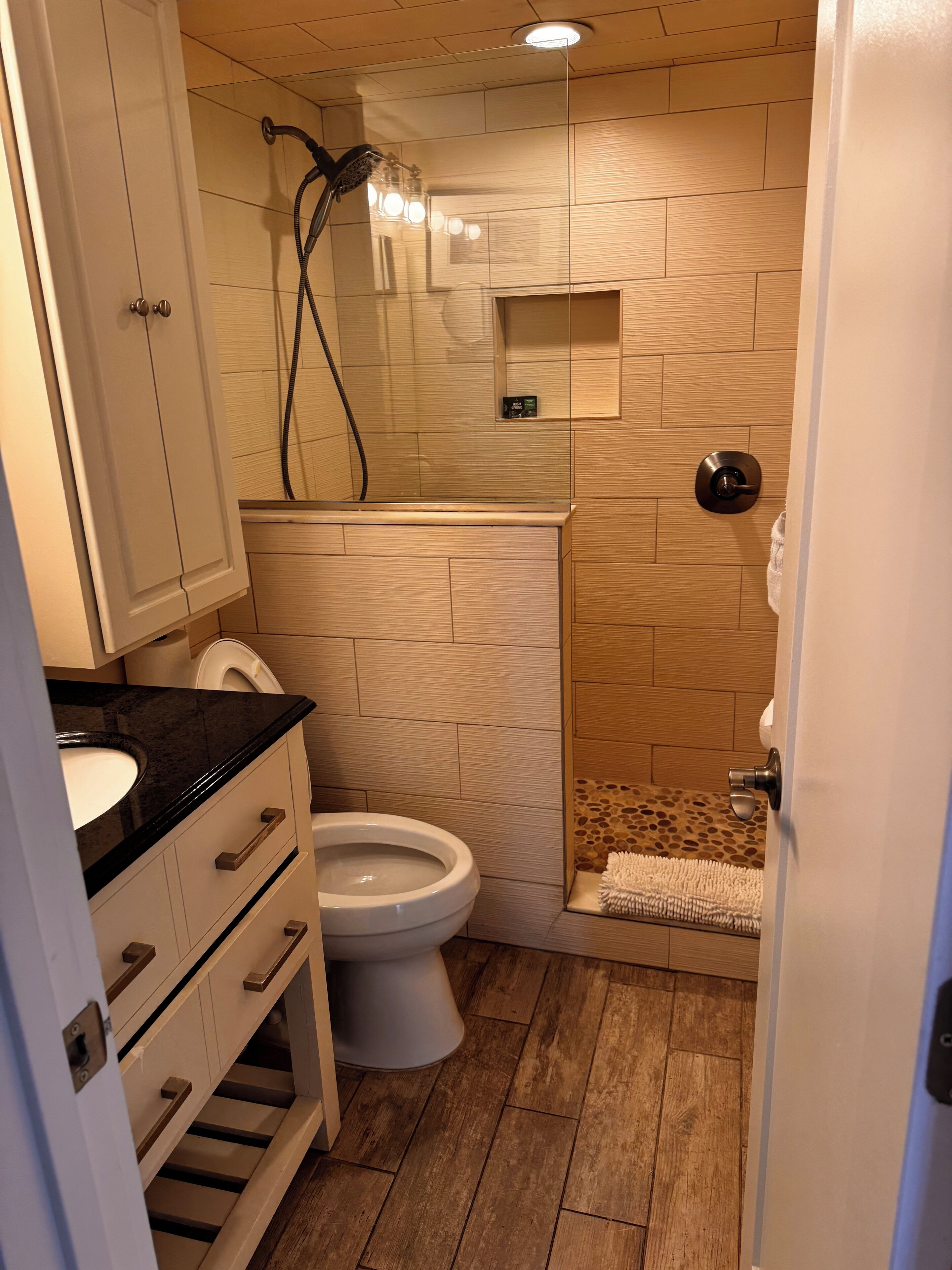 A bathroom with a toilet, sink, and shower area.