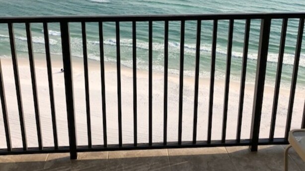 Ein Balkon mit Blick auf das Meer und den Strand.