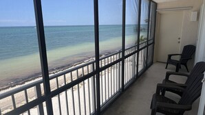 Ein Balkon mit Blick auf Strand und Meer.