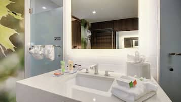 Un baño moderno con un espejo grande, dos lavamanos y un perchero para toallas.