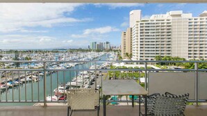 A balcony with a view of a marina and a hotel building. - Chic 2-Bedroom Unit In 43 Stack In The Ilikai Hotel! (Honolulu)