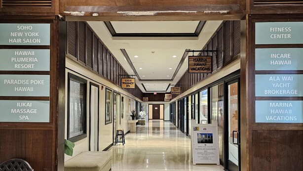 A corridor with a sign for Ilikai Shops at the entrance. - Perfect Location In Waikiki, Near Beach, Shopping, and Dining! (Honolulu)