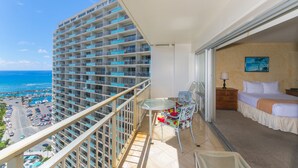A balcony with a view of the ocean and a hotel room with a bed and a chair. - Perfect One-Bedroom Unit with an Ocean View! Ilikai Hotel, Great Location!  Going fast!  A++++ (Honolulu)