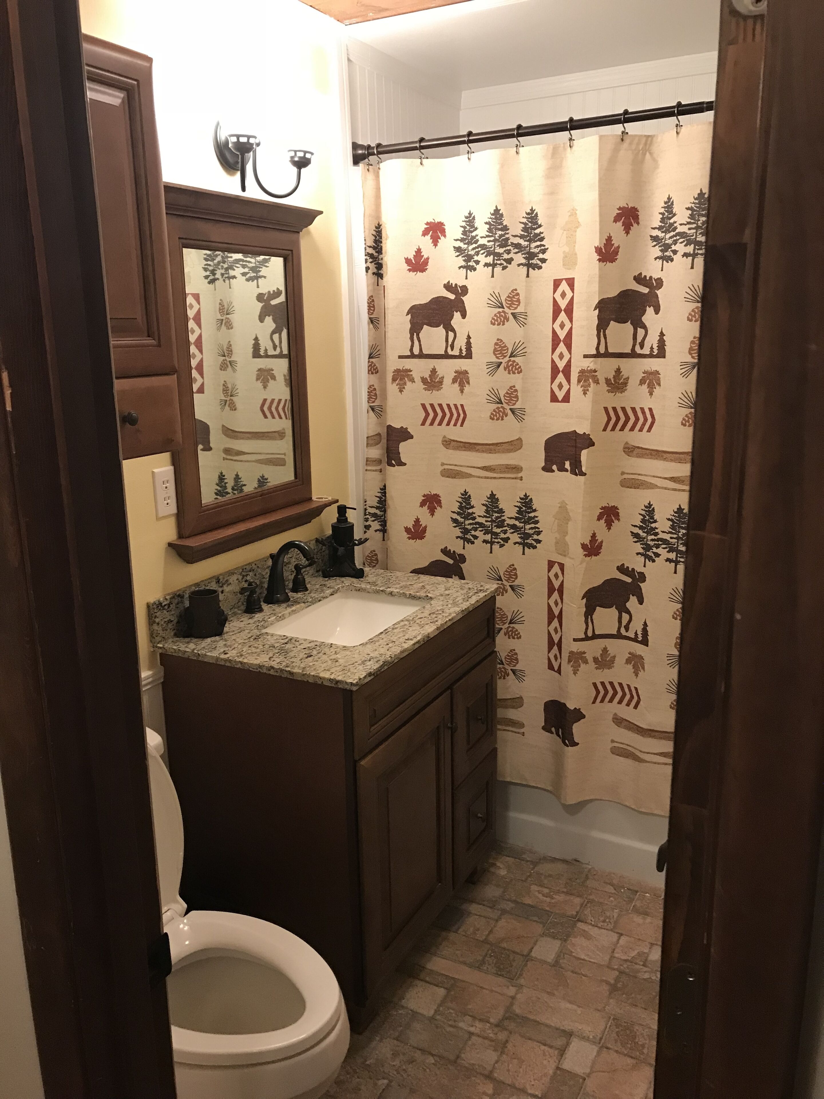 Un baño con inodoro, lavamanos y espejo.