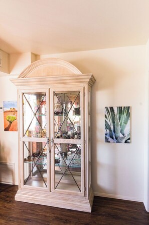 A room with a glass-fronted cabinet containing various items. - Local Artists Bohemian Loft (Sedona)