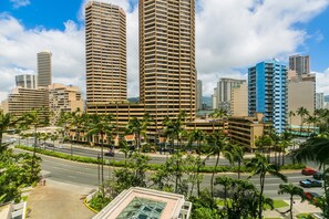 Un horizonte urbano con edificios altos, palmeras y una carretera.
