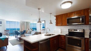 A modern kitchen with stainless steel appliances, wooden cabinets, and a large island with a sink.