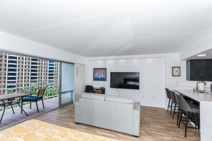 En moderne lejlighed med balkon, spiseområde, opholdsstue og køkken.