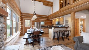 Ein Holzblockhaus mit Essbereich, Küche und Wohnbereich.