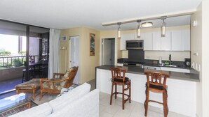 Un espace de vie compact doté d’un balcon, d’une kitchenette et d’un coin repas.
