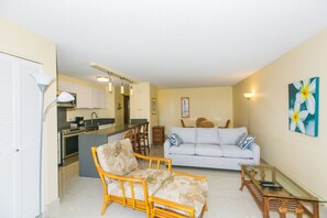 Cozy living space with a kitchenette, sofa, armchair, and coffee table.