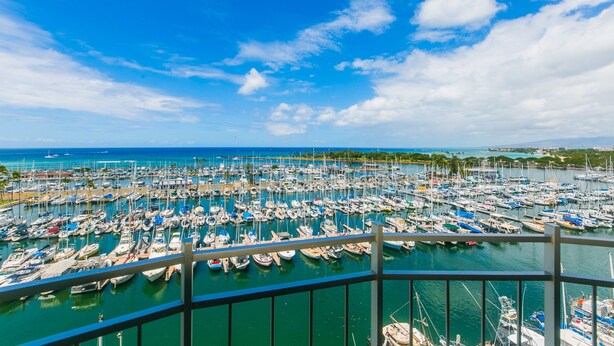 A marina filled with boats, a clear blue sky, and a distant shoreline with buildings and greenery. - Marina Hawaii Vacations - Beautiful 180 Degree Ocean Views! (Honolulu)