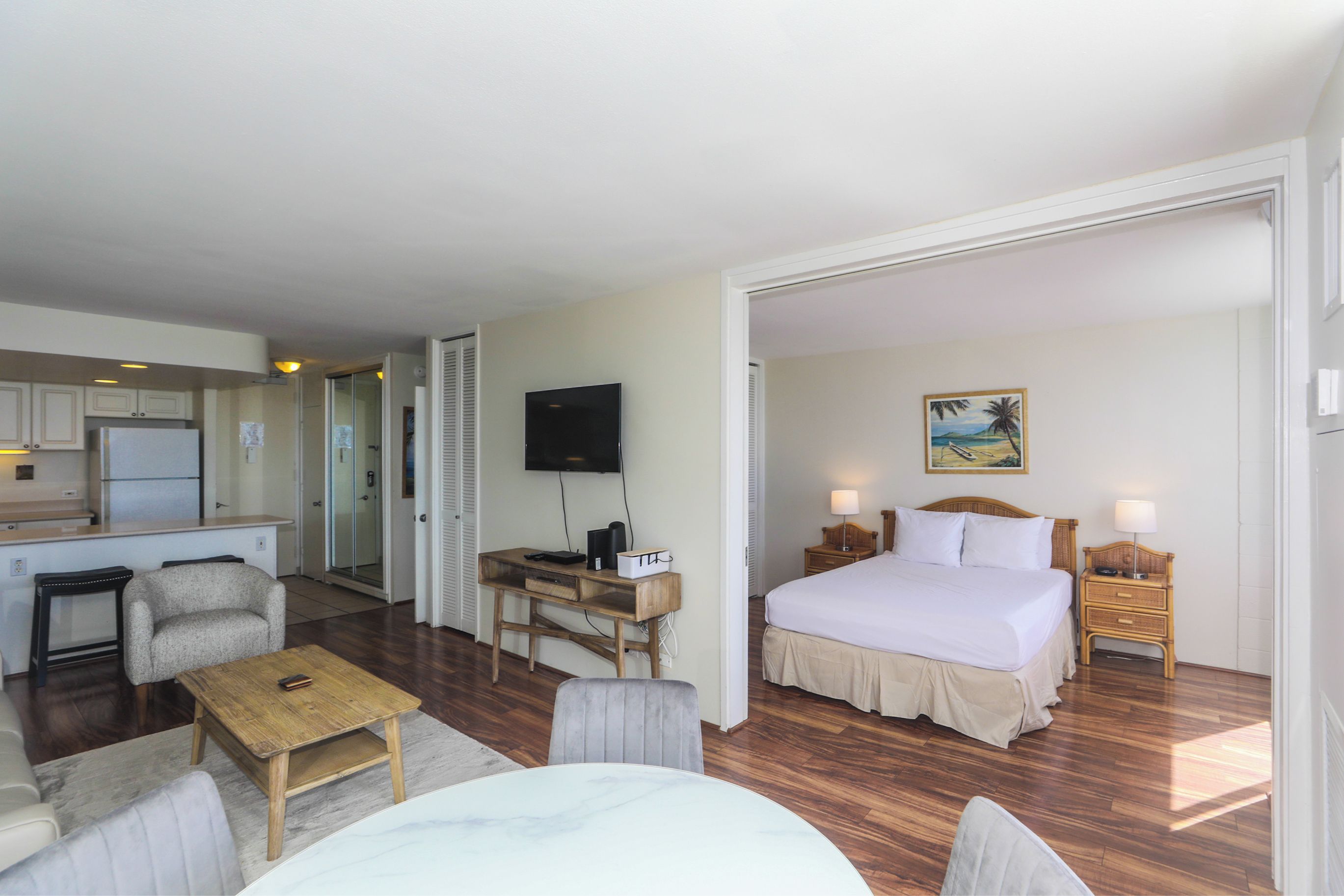 Une chambre d’hôtel avec un lit, un bureau, une télévision et un tableau au mur.