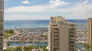 Hotel alto com vista para uma marina, barcos e o oceano.
