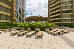 Une terrasse sur le toit, dotée d’un espace extérieur aménagé et d’un grand bac central rempli de plantes.