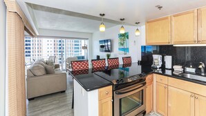 Una cocina moderna con una isla central, armarios de madera y un amplio ventanal con vistas a la ciudad.