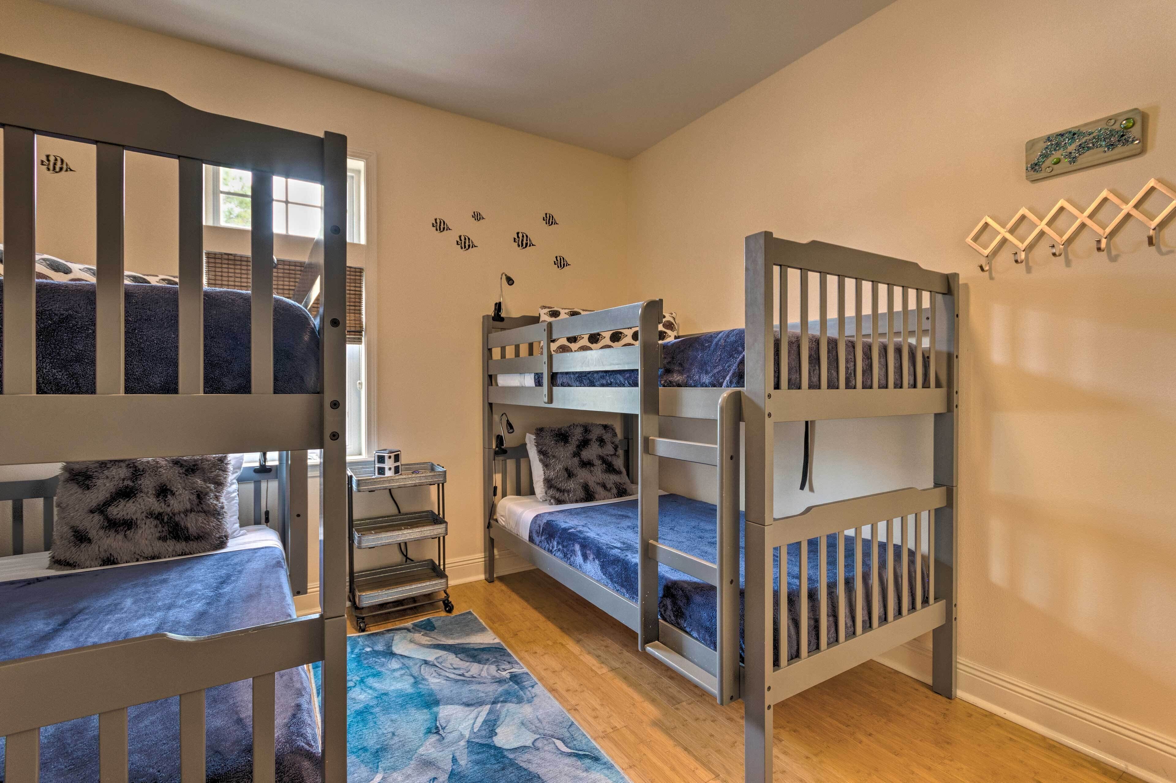 A room with bunk beds, a desk, and a small window.
