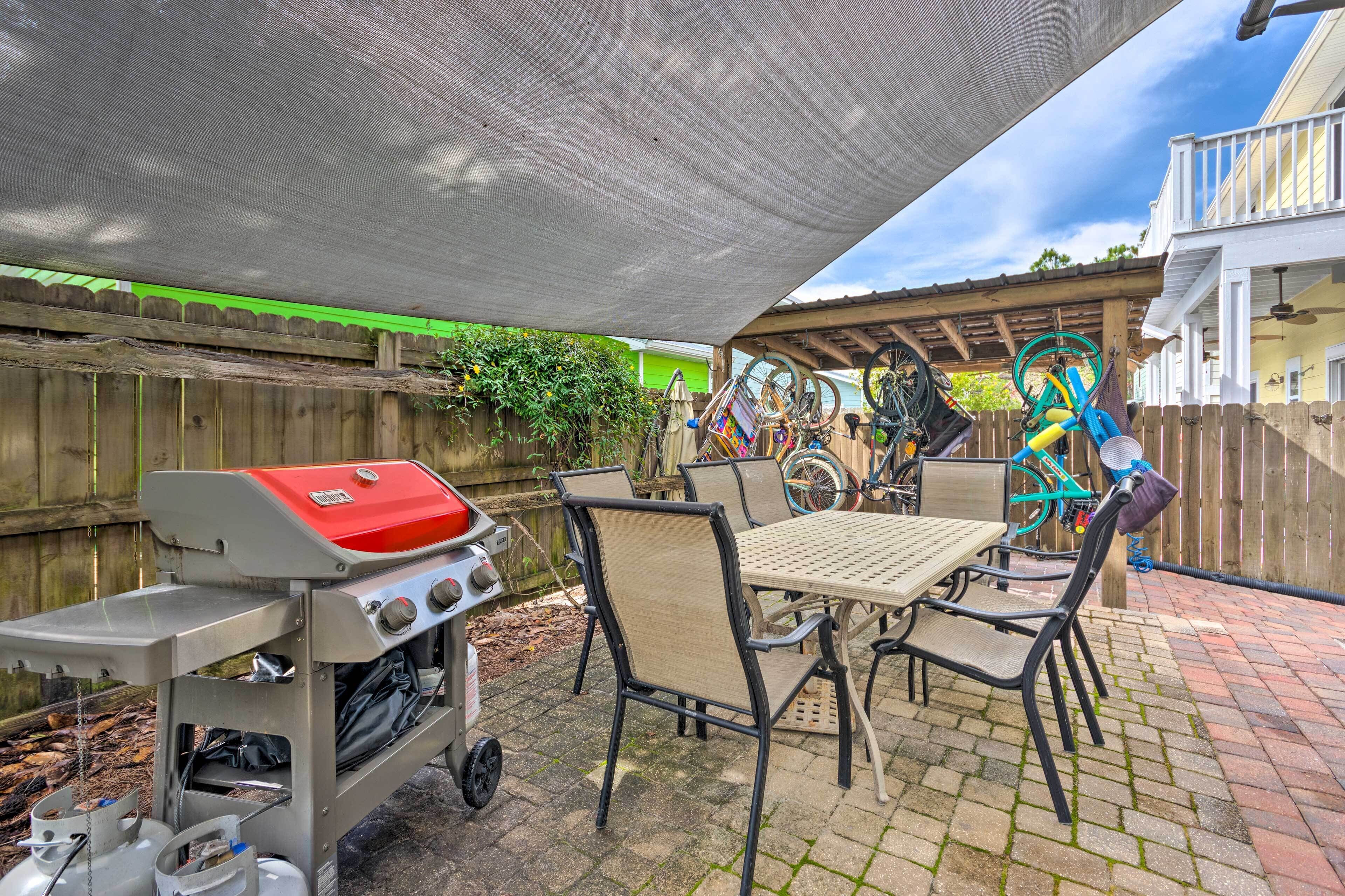 Une terrasse extérieure équipée d’un barbecue, d’une table et de chaises.