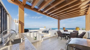 Portico esterno coperto con lavello, barbecue e zona salotto con vista sul mare.